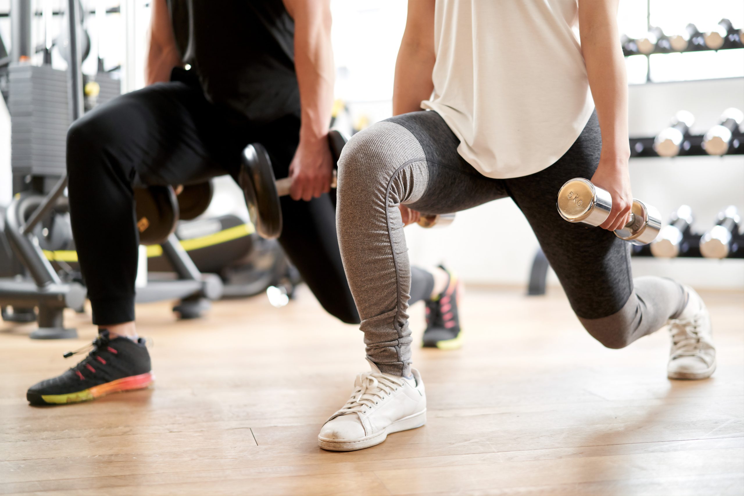 Asian couple doing dumbbell front lunge